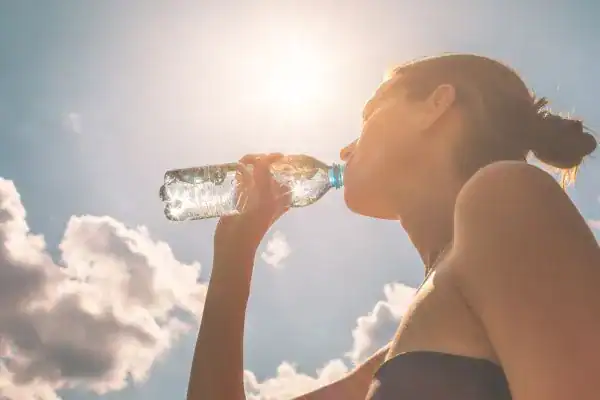 Hydration: The Secret Ingredient for a Toned Stomach and Enhanced Fitness 3 Image of woman drinking water to hydrate Bexhill after run.